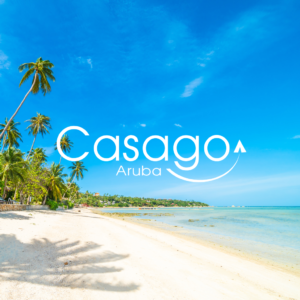 Pristine white sandy beach with turquoise waters and palm trees under a bright blue sky, featuring the Casago Aruba logo for vacation rentals.